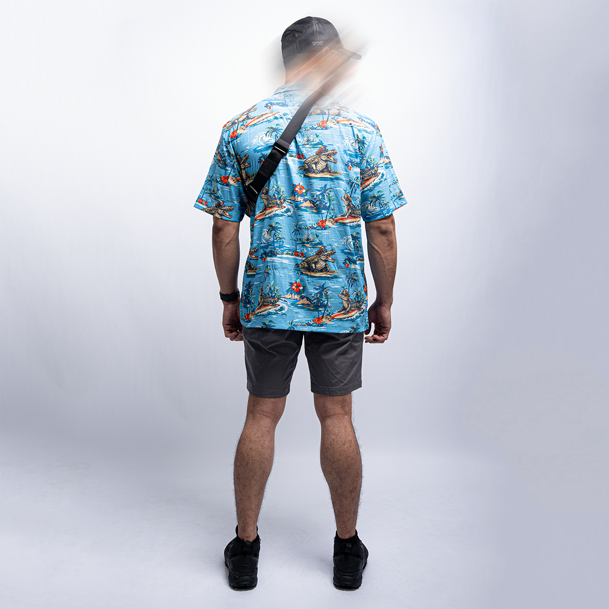 นักสวมเสื้อลายดอกไฮวายันสีฟ้า พร้อมกระเป๋าสะพายข้างสีดำ มองจากด้านหลัง Lifestyle เสื้อออเดอร์ Hawaii VALOR Tactical