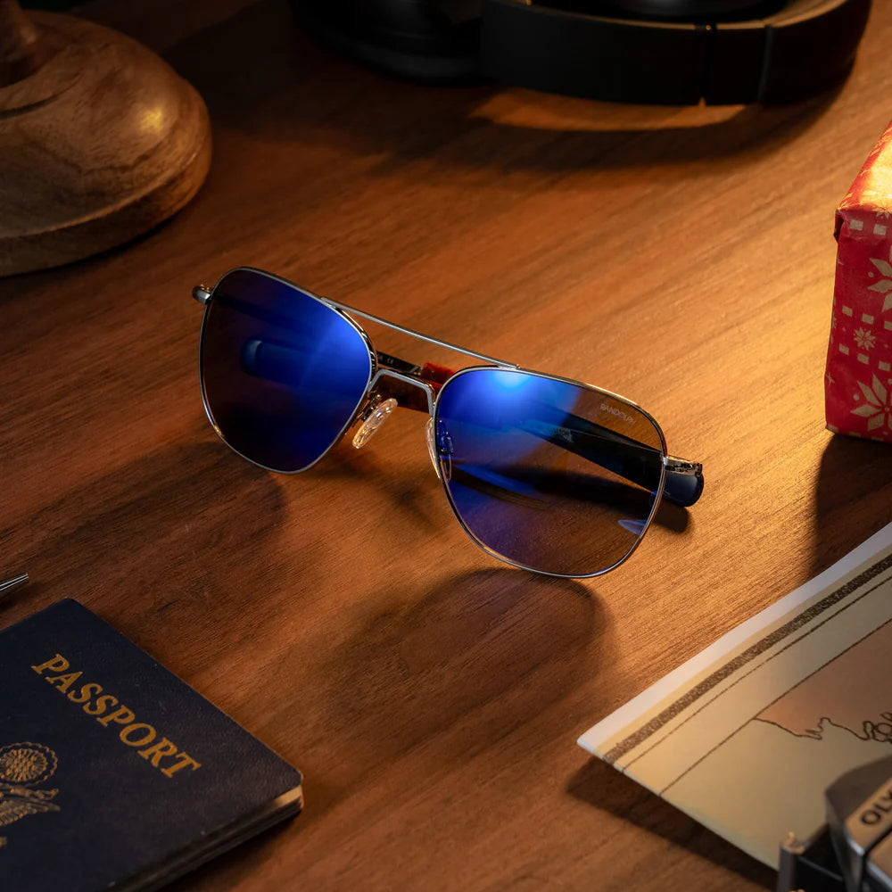 แว่นตา Randolph - Aviator Gunmetal & Atlantic Blue เลนส์สีฟ้า วางอยู่ บนโต๊ะ